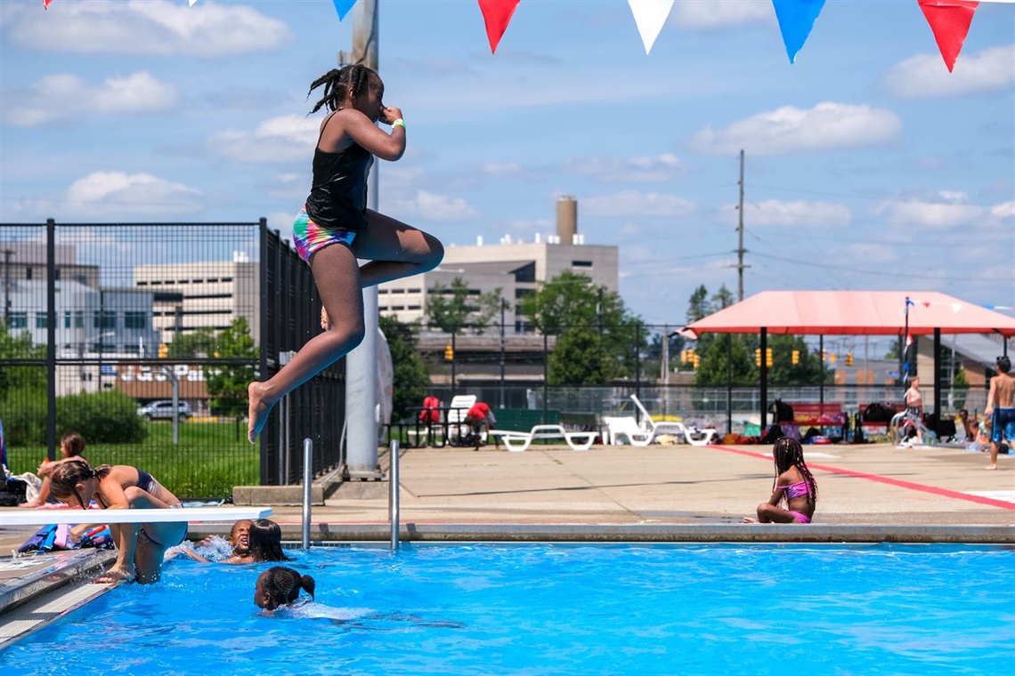 a girl jumps off the diving board at kik pool