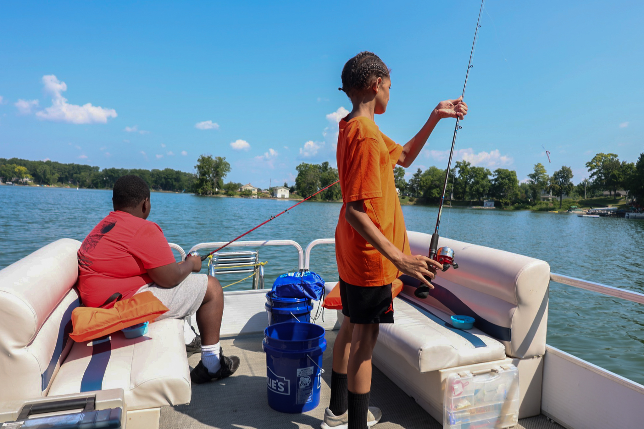A photo of youth fishing on a boat. 