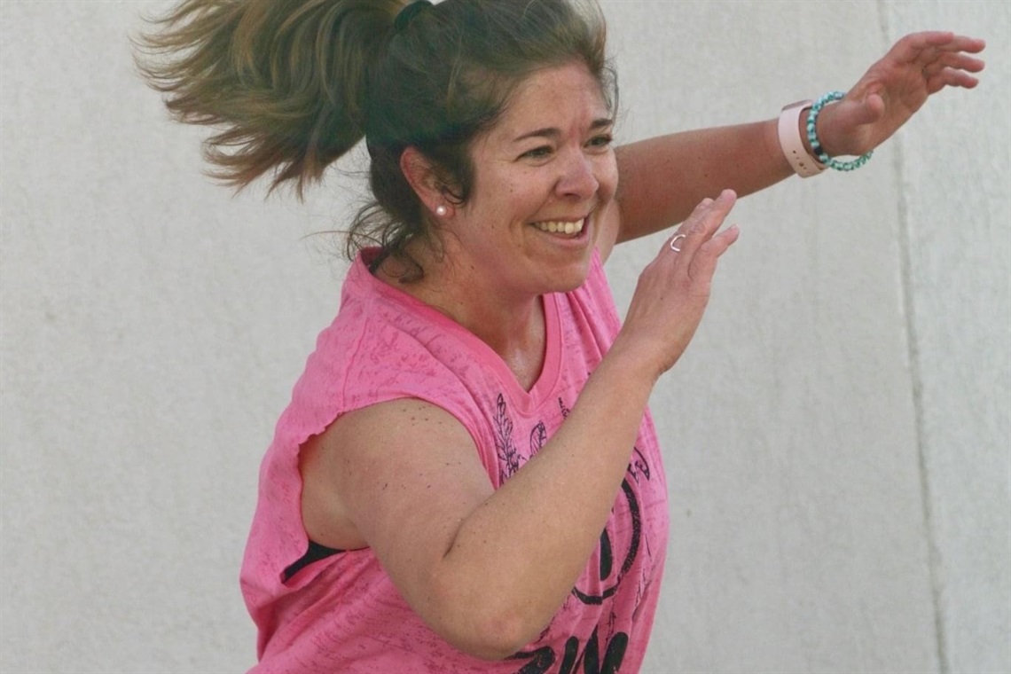 A photo of a Zumba instructor wearing a pink shirt.